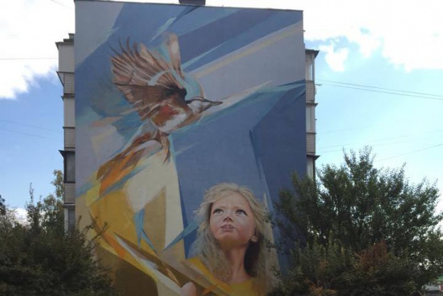На стене столичной многоэтажки появилось изображение девочки с птицей (фото)